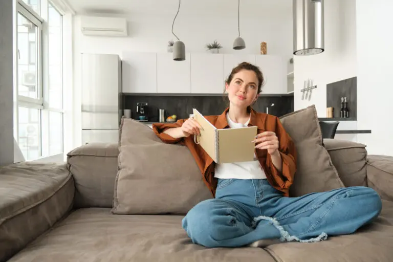 žena číta knihu na gauči, má pustenú klimatizáciu